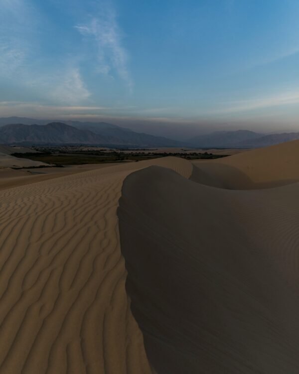 Scenic view of the Huacachina sand dunes in Ica, Perú at sunset, showcasing natural beauty.